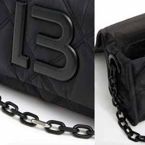 Padded nylon crossbody bag in black. Small model with long chain strap.